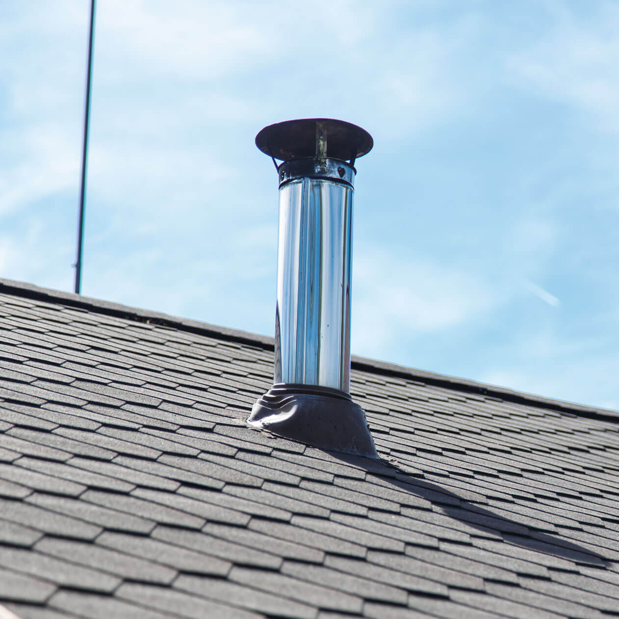 Chimney pipe from stainless steel on the roof of the house.